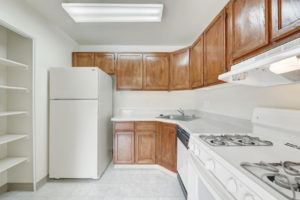 kitchen with white appliances, brown cabinets, large built in shelves